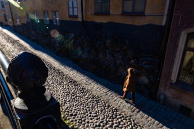 Stockholm, İsveç 16 Mayıs 2025. Sodermalm 'da Brannkyrkagatan caddesinde bir kadın yaya yürüyor..