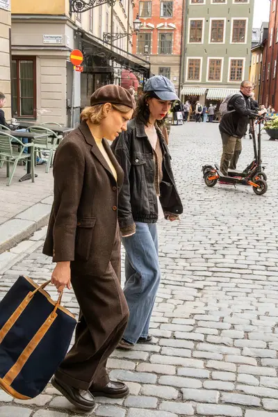 Stockholm, İsveç 18 Mayıs 2025 Gamla Stan ya da Old Town 'daki bir kafe dışındaki genç trend kadınlar.