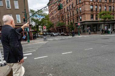 New York, New York, ABD 24 Mayıs 2025 Son sınıf öğrencisi Columbus Bulvarı 'nda bir taksi durdurdu..