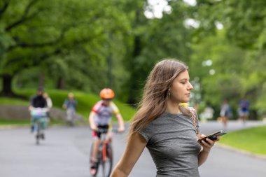 New York, New York, ABD 24 Mayıs 2025 Bisikletçi ve genç bir kadın Central Park 'ta West Drive' da yaya..