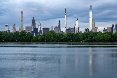 New York, New York, ABD Central Park rezervuarı ve gökdelenli gökyüzü manzarası.