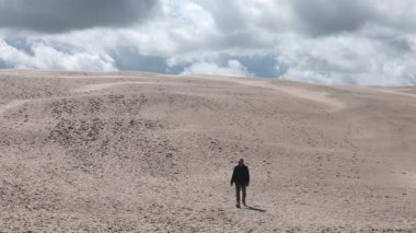 Skagen, Danimarka Rbjerg Mile 'ın kum tepelerinde bir adam yürüyor..