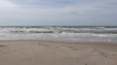 Hirtshals, Danimarka Kuzey Denizi sahilinde bir adam dondurma ile yürüyor.. 