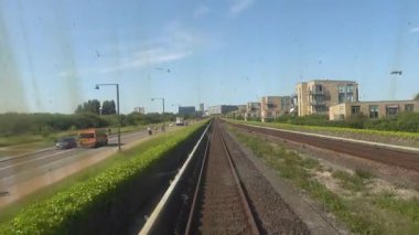 Kopenhag, Danimarka M1 hattında yükseltilmiş bir metro treni Orestad bölgesindeki modern binalardan geçiyor..