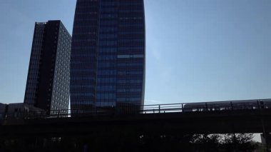 Kopenhag, Danimarka M1 hattında yükseltilmiş bir metro treni Orestad bölgesindeki modern binalardan geçiyor..  