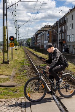 Jonkoping, İsveç 30 Mayıs 2025 Bir bisikletçi Piren bölgesindeki raylardan geçiyor.