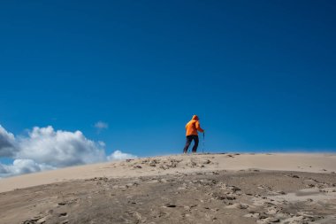 Skagen, Danimarka 2 Haziran 2025 Rabjerg Mil 'in rüzgârlı kum tepelerinde yürüyen insanlar.