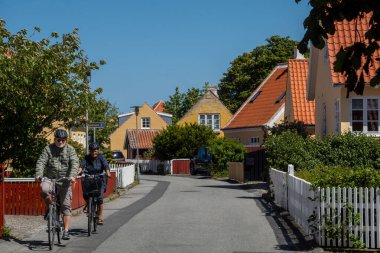 Skagen, Danimarka 2 Haziran 2025. Şehir merkezindeki güzel bir sokakta bisiklete binen bir çift..