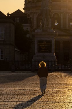 Kopenhag, Danimarka. Amelienborg Kraliyet Sarayı meydanında bir kadın siluet içinde yürüyor..