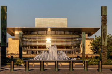 Kopenhag, Danimarka 12 Haziran 2025 Amalienborg Palalce 'deki çeşmenin etrafında yürüyen insanlar ve gün batımında limandaki Kraliyet Opera Evi.