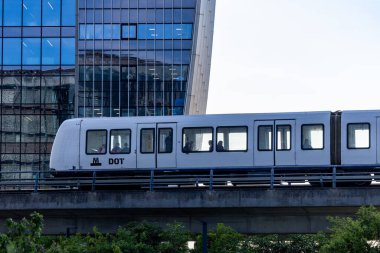 Kopenhag, Danimarka 12 Haziran 2025 M1 hattındaki yüksek bir metro treni Orestad bölgesindeki modern binalardan geçiyor..