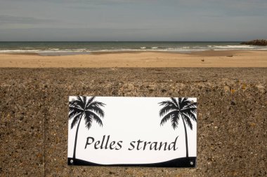 Hirtshals, Danimarka 3 Haziran 2025 Deniz kenarında palmiye ağaçları olan komik bir tabela Pelles Caddesi veya Pelles Sahili diyor ki orada palmiye ağaçları yok..
