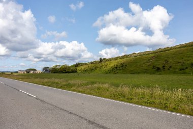 Mors, Danimarka Kuzey Jutland Limfjord 'daki Mors adasındaki yemyeşil manzara ve otların arasından geçen bir yol..