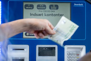 Nyborg, Stora Belt, Danimarka 11 Haziran 2025 Büyük Kemer Köprüsü 'ndeki bir gişede geçiş ücreti ödemek için makineyi kullanan bir sürücü şöyle diyor:.
