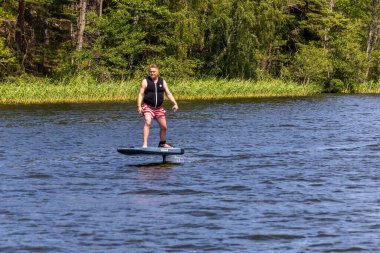 Stockholm, İsveç 2 Temmuz 2025 Bir adam suyun üzerinde elektrikli bir hava folyosu sürüyor