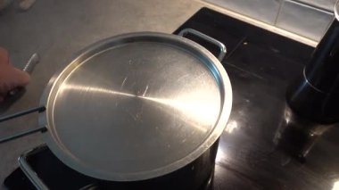 Stockholm, İsveç. Bıçaklı bir el mutfaktaki buharda pişirilmiş brokolinin hazır olup olmadığını kontrol eder.. 