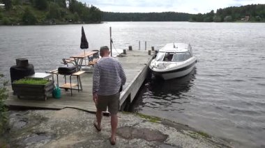 Stockholm, İsveç 'te bir adam Malaren Gölü' ndeki bir kulübede ve rıhtımda bir tekne boşaltıyor.. 