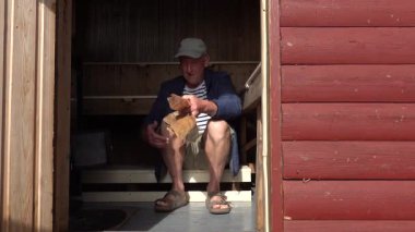 Stockholm, İsveç Bir adam odun ateşinde sauna yakmak için odun kullanır. 