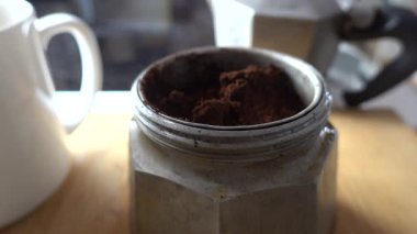 Stockholm, İsveç 'te bir insan ocağın tepesindeki espresso makinesini öğütülmüş kahve filtresiyle doldurur.. 