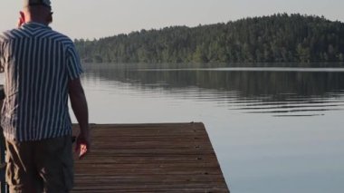 Stockholm, İsveç 'te bir adam Malaren Gölü' nde ahşap bir iskelede yürüyor..