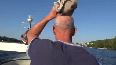 Stockholm, İsveç Bir adam sürat teknesi kullanıyor ve sıcak rüzgarın tadını çıkarıyor.