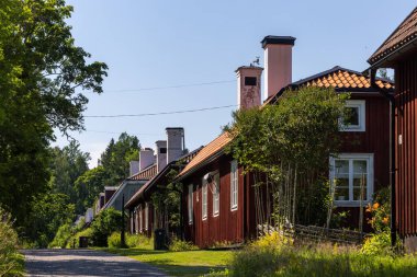 Bergby, İsveç. Vifors 'taki Gastrikland bölgesinde bacaları olan kırmızı kereste yerleşim yerleri ve geleneksel evler..