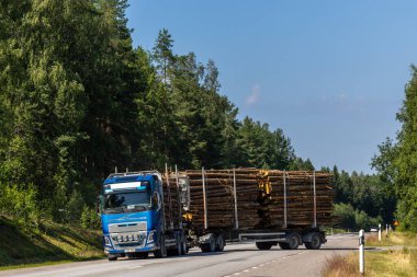 Bergby, İsveç 15 Temmuz 2025 Tam donanımlı ve eklemli bir kereste kamyonu yola çıkıyor.