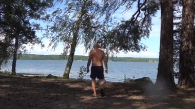 Stockholm, İsveç Baltık Denizi kıyısında ağaçlık bir sahilde bir adam yürüyor.. 