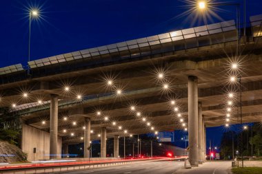 Stockholm, İsveç geceleri Liljeholmen 'deki E4 karayolu köprüsünün altında trafik çizgileri.