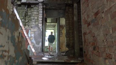 Irbene, Letonya. Bir adam terk edilmiş Sovyet apartmanlarını araştırıyor..