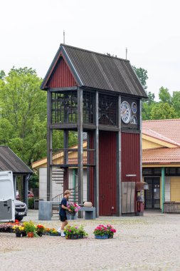 Ventspils, Letonya 29 Temmuz 2025 Bir çiçek satıcısı ana pazar meydanındaki çan kulesinin yakınına çiçek kurar.