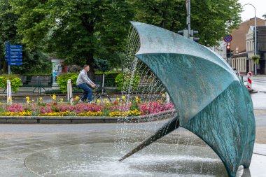Ventspils, Letonya 29 Temmuz 2025 Şemsiye Pınarı, Fountain Lietussargs ve bir bisikletçi, yazan Gleb Panteleyev.