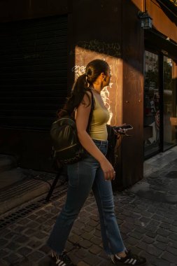 Cagliari, Sardinya, İtalya 5 Ağustos 2025 Eski Şehir 'de batan güneşte bir kadın yürüyor.