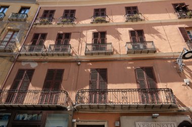 Cagliari, Sardinya, İtalya 6 Ağustos 2025 Balkonlu bir apartmana pembe bir cephe.