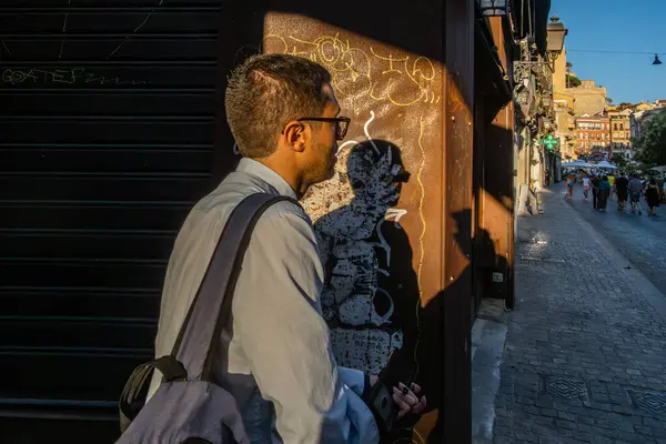 Cagliari, Sardinya, İtalya 5 Ağustos 2025 Eski Şehir 'de bir adam batan güneşte yürüyor.