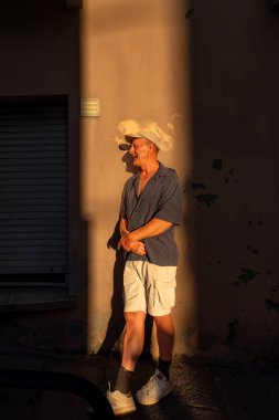 Cagliari, Sardinya, İtalya Bir adam arka sokakta gün batımının ışığında duruyor.