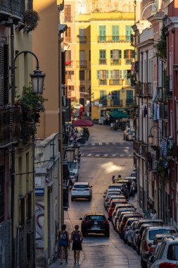 Cagliari, Sardinya, İtalya 6 Ağustos 2025 Via Domenico Alberto Azuni 'de şehir merkezindeki Piazza Yenne Cagliari' ye doğru giden yaya ve arabalar..
