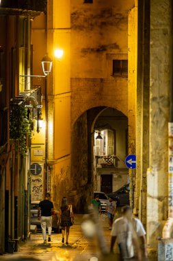 Cagliari, Sardinya, İtalya 10 Ağustos 2025 Tarihi şehir merkezinde Via Ospedale 'de yürüyen bir çift.