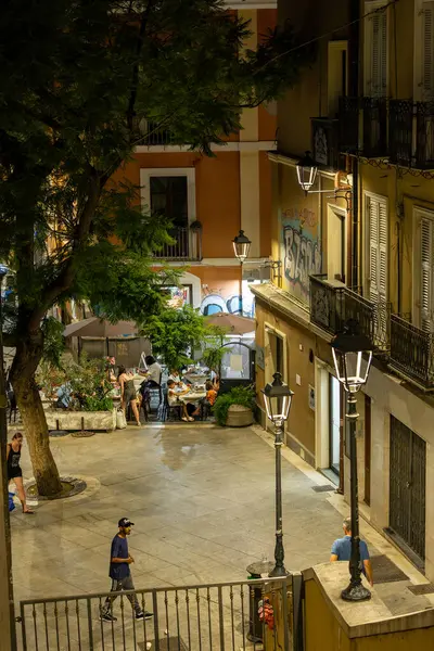 Cagliari, Sardinya, İtalya 8 Ağustos 2025 Geceleyin tarihi bir kasabada arka sokakta yürüyen insanlar.