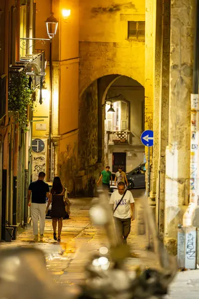 Cagliari, Sardinya, İtalya 10 Ağustos 2025 Tarihi şehir merkezinde Via Ospedale 'de yürüyen bir çift.