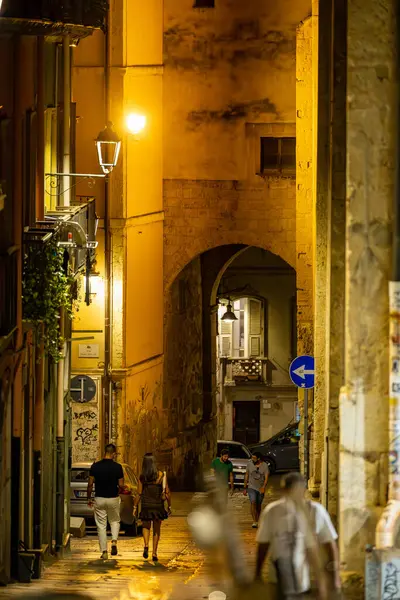 Cagliari, Sardinya, İtalya 10 Ağustos 2025 Tarihi şehir merkezinde Via Ospedale 'de yürüyen bir çift.