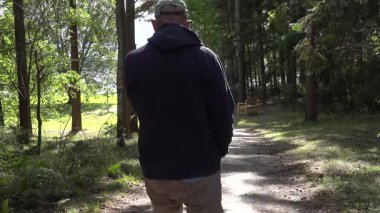 Enkoping, İsveç Kırsalda ağaçlık bir sokakta bir adam yürüyor. 