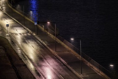 Stockholm, İsveç Kvarnholmen bölgesinden şehrin yağmurunda boş bir caddenin gece manzarası.