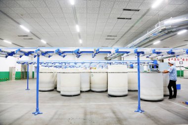 LUANNAN COUNTY - 20 Aralık 2013 'te, Luannan Eyaleti, Hebei Eyaleti, Çin' deki ZeAo Spin LTD 'deki bir üretim atölyesinde mekanik ekipmanlar çalışıyordu..