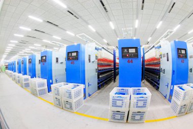 LUANNAN COUNTY - 20 Aralık 2013 'te, Luannan Eyaleti, Hebei Eyaleti, Çin' de, ZeAo Spin LTD 'de bir üretim atölyesinde dönen makine ve plastik sandık.