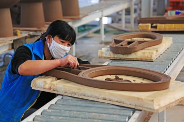 LUANNAN COUNTY - 5 Ocak 2014, Luannan Eyaleti, Hebei Eyaleti, Çin 'deki ZhongTong Seramik Şirketi' nde seramik yarı bitmiş ürünleri tamir eden kadın işçiler