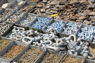 Demir bir kutuda metal parçalar ve bağlayıcılar, fotoğrafın yakın çekimi.