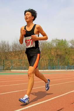 LUANNAN COUNTY - 10 Nisan 2014 'te okul bahçesinde koşan 10: 3000 m mesafe koşucusu, Luannan County, Hebei Eyaleti, Çin.