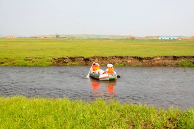 TULIGEN GRASSLAND - 20 Temmuz 2014: Ziyaretçiler Tuligen Nehri 'nde 20 Temmuz 2014 tarihinde şişme sandal sürüklenmesi, Xilin gol ligi, Moğolistan özerk bölgesi, Çin.