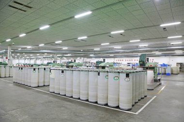 Fabrikada dönen makine parçaları ve beyaz plastik kovalar, yakın çekim